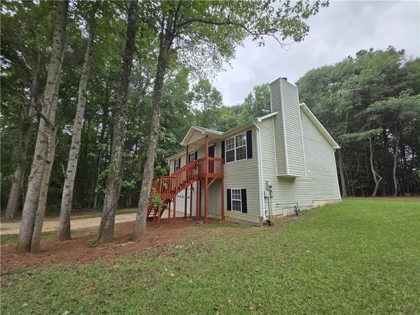 a view of a house with backyard and trees