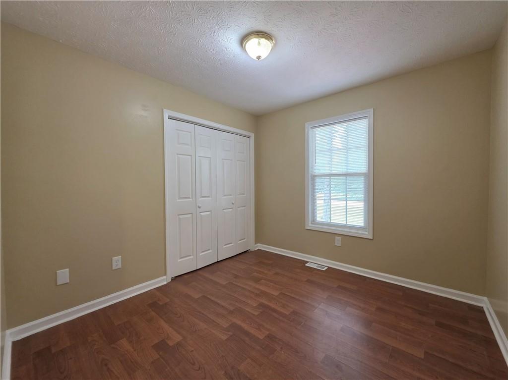 186 South Red Oak Way Temple, GA 30179 - Photo 9 of 19 an empty room with wooden floor and windows