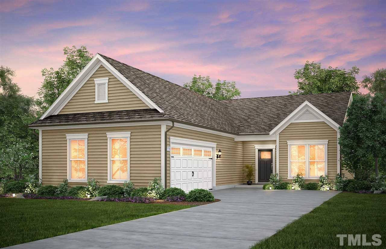 a front view of a house with a yard and potted plants