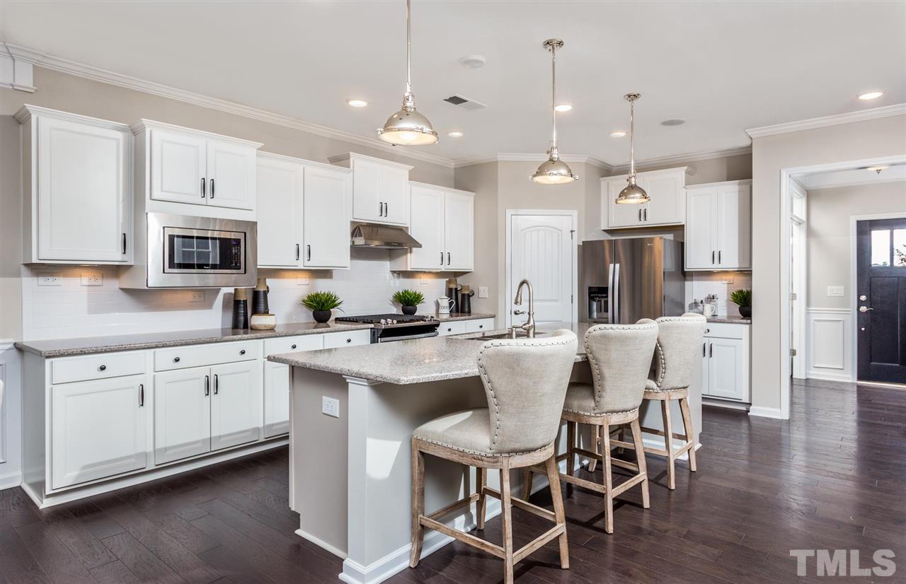 704 Haven Peak Lane Wake Forest, NC 27587 - Photo 11 of 28 a kitchen with kitchen island granite countertop a white cabinets and chairs