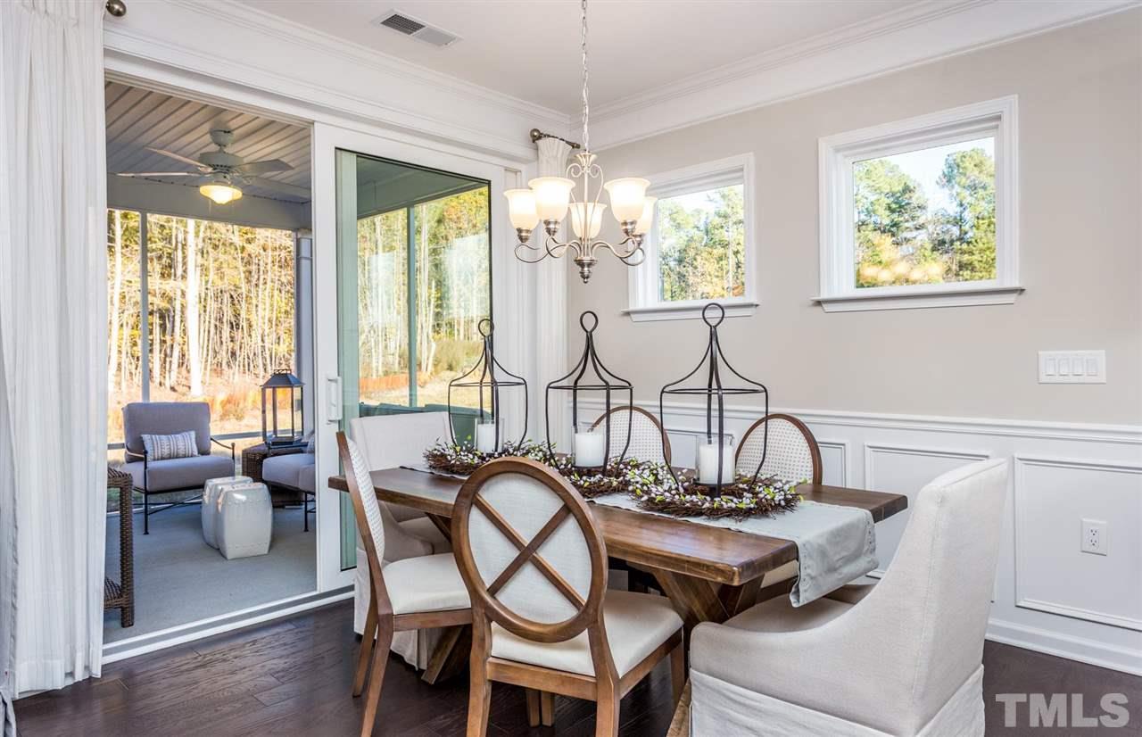 704 Haven Peak Lane Wake Forest, NC 27587 - Photo 15 of 28 a view of a dining room with furniture a chandelier and large windows