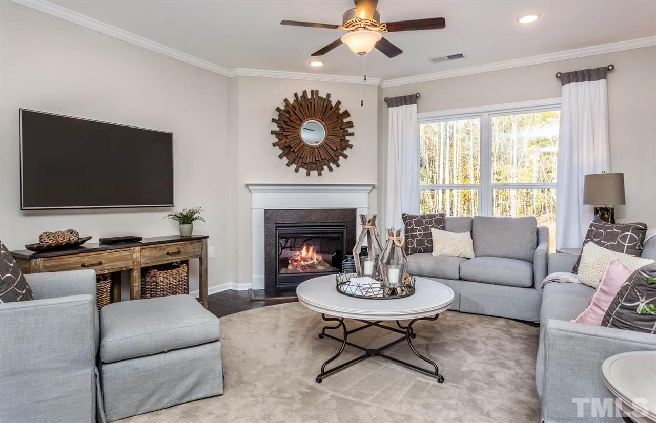 704 Haven Peak Lane Wake Forest, NC 27587 - Photo 7 of 28 a living room with furniture a fireplace and a flat screen tv