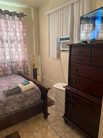 a bedroom with a bed and a mirror on the dresser