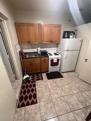a kitchen with a stove a refrigerator and wooden cabinets