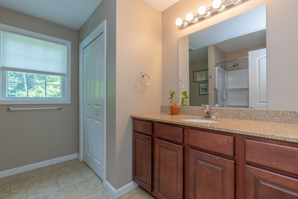 247 Cabinet Street Springfield, MA 01129 - Photo 29 of 40 a bathroom with a granite countertop sink a mirror and a vanity