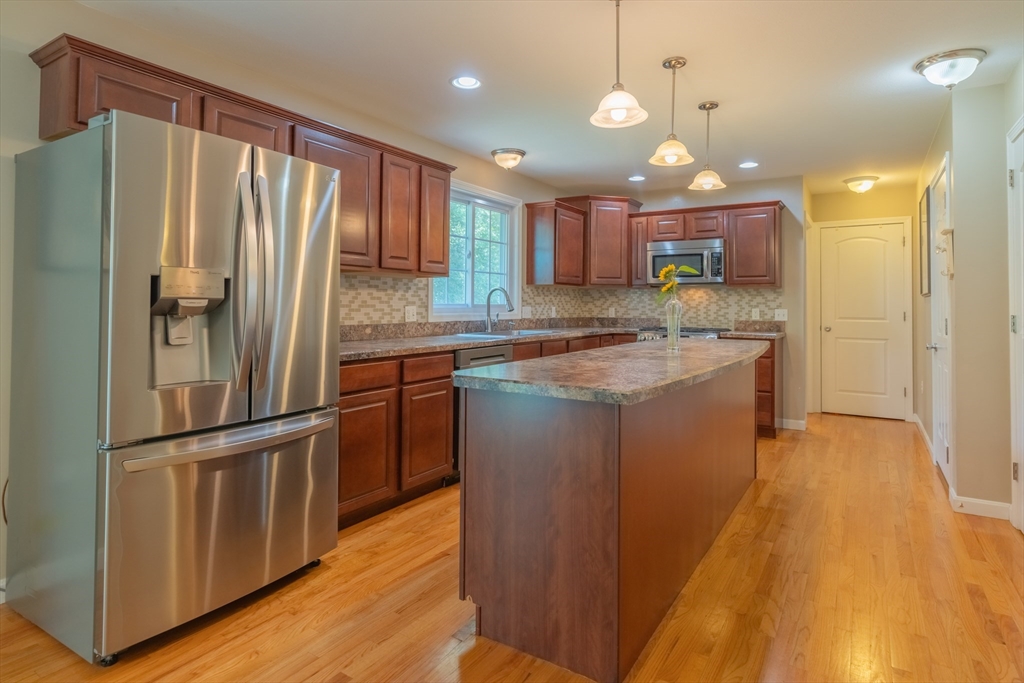 247 Cabinet Street Springfield, MA 01129 - Photo 8 of 40 a kitchen with stainless steel appliances granite countertop a refrigerator a sink dishwasher a stove and white countertops with wooden floor
