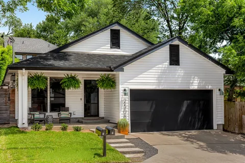 a front view of a house with a yard garden and outdoor seating