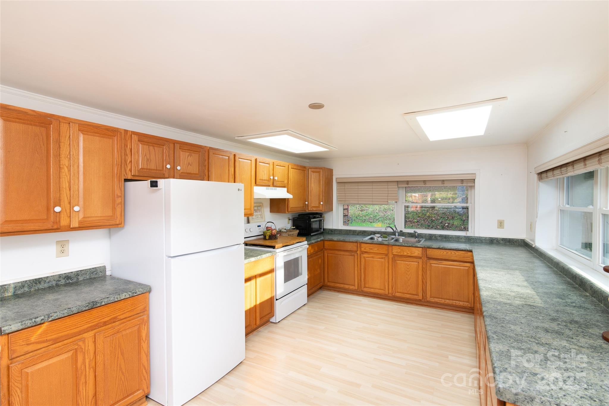 1137 Saunders Road Franklin, NC 28734 - Photo 13 of 30 a kitchen with stainless steel appliances granite countertop a refrigerator a stove and a sink with large window