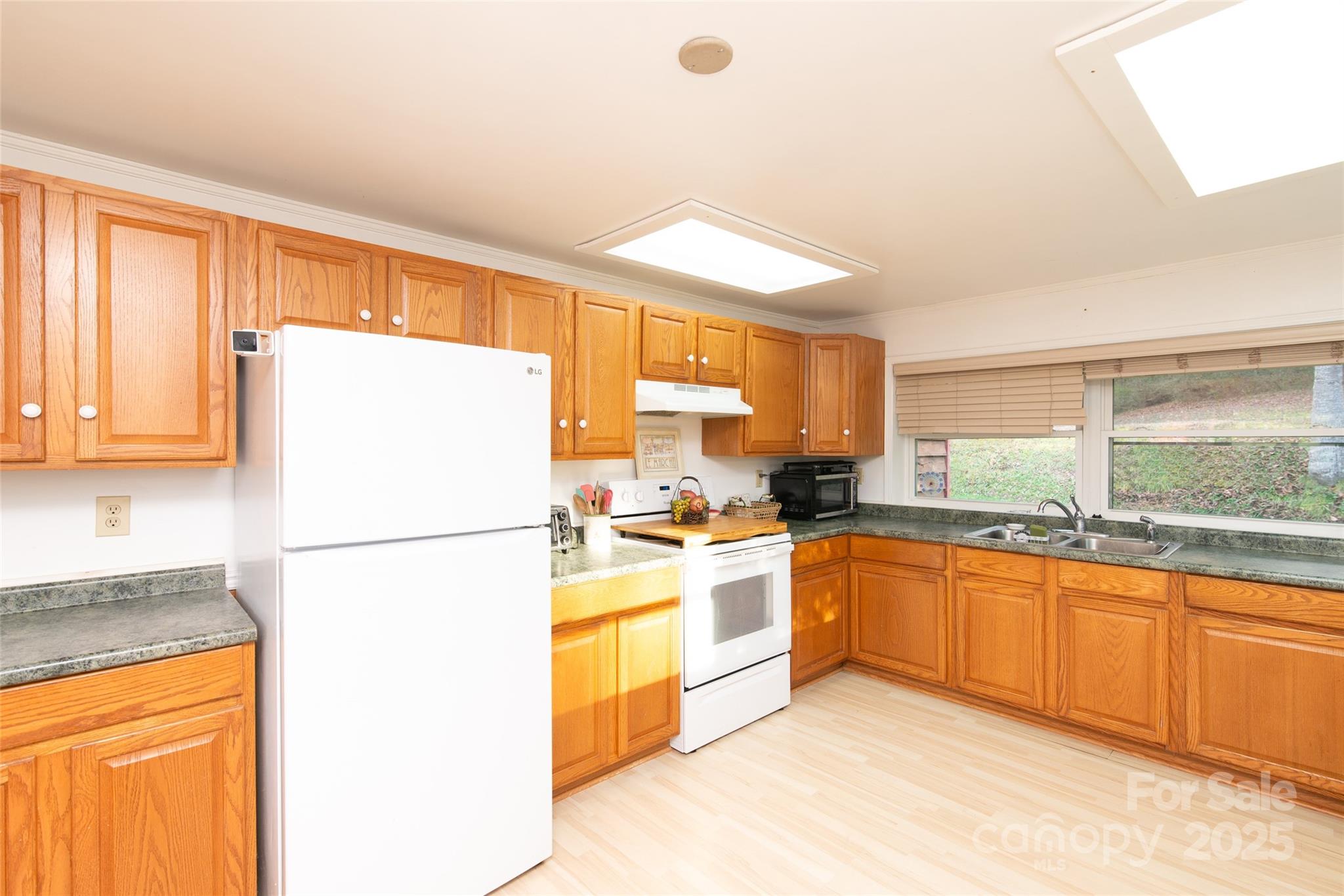 1137 Saunders Road Franklin, NC 28734 - Photo 14 of 30 a kitchen with a refrigerator a stove a sink and cabinets