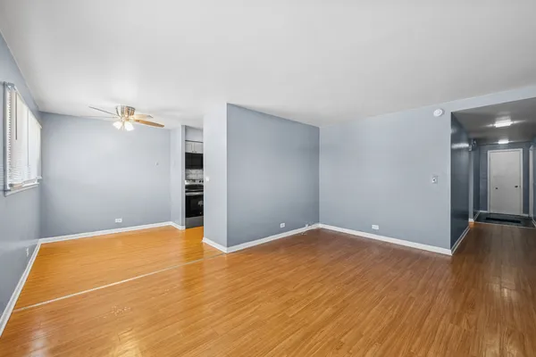 a view of empty room with wooden floor