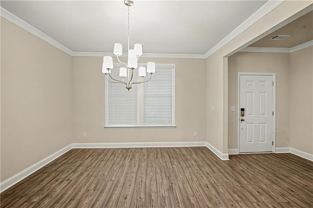 3068 Shirecrest Lane Dacula, GA 30019 - Photo 11 of 41 a view of a room with wooden floor and chandelier