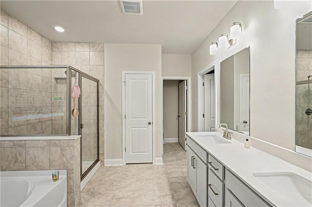 3068 Shirecrest Lane Dacula, GA 30019 - Photo 31 of 41 a bathroom with a double vanity sink a large mirror and a shower