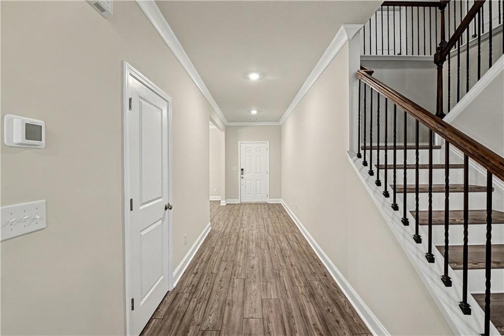 3068 Shirecrest Lane Dacula, GA 30019 - Photo 9 of 41 a view of a hallway with wooden floor and staircase