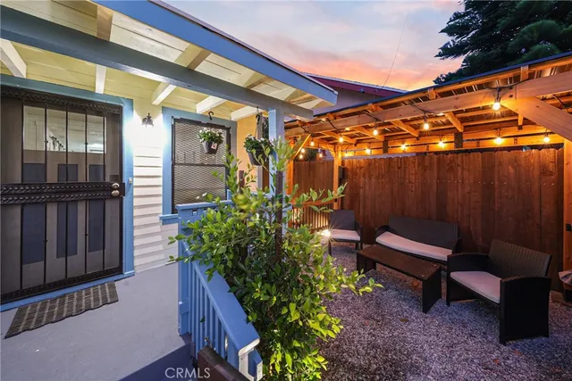 a backyard of a house with chairs and wooden fence