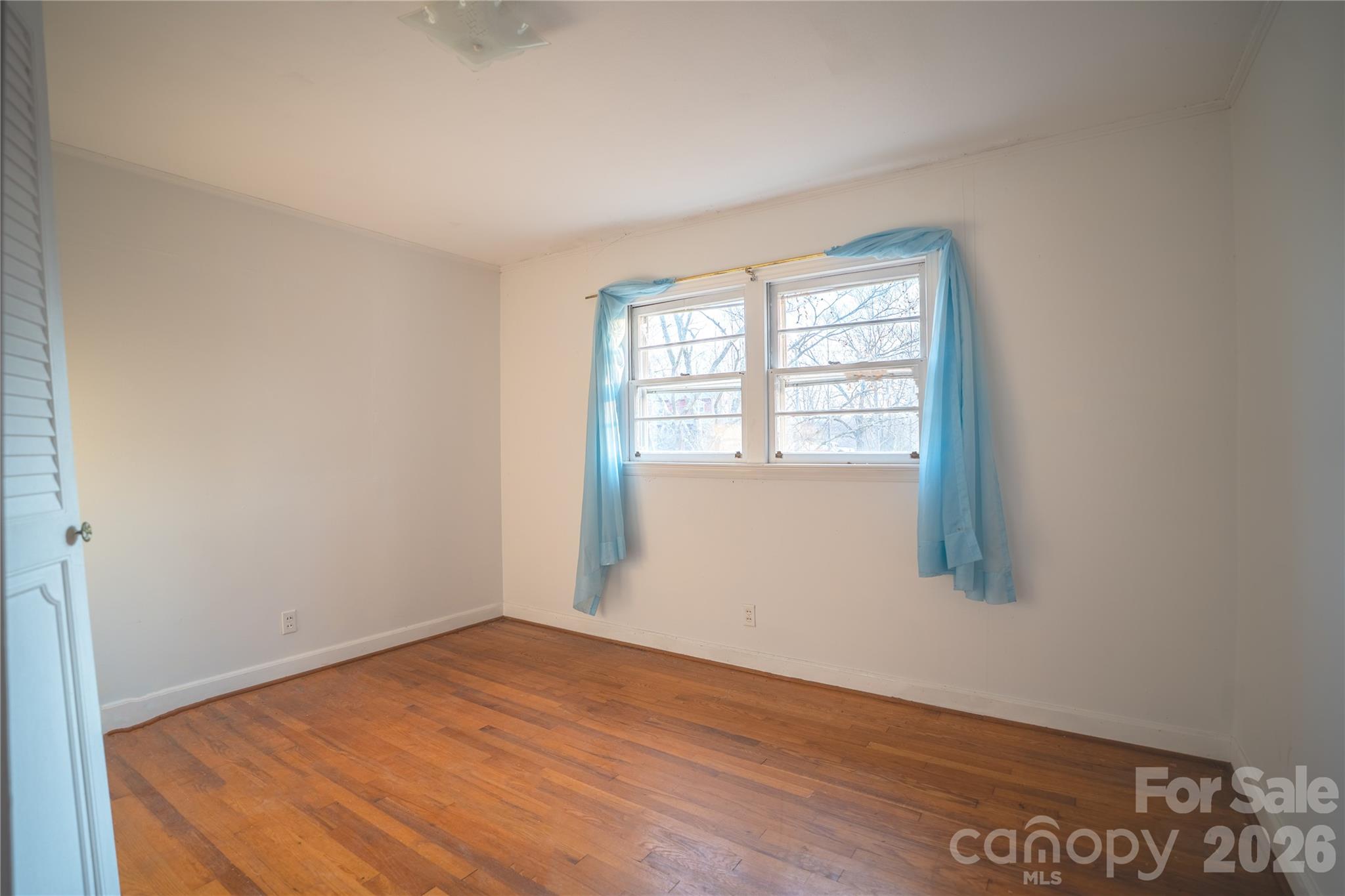 859 Stacy Hill Road Marion, NC 28752 - Photo 12 of 23 a view of an empty room with wooden floor and a window