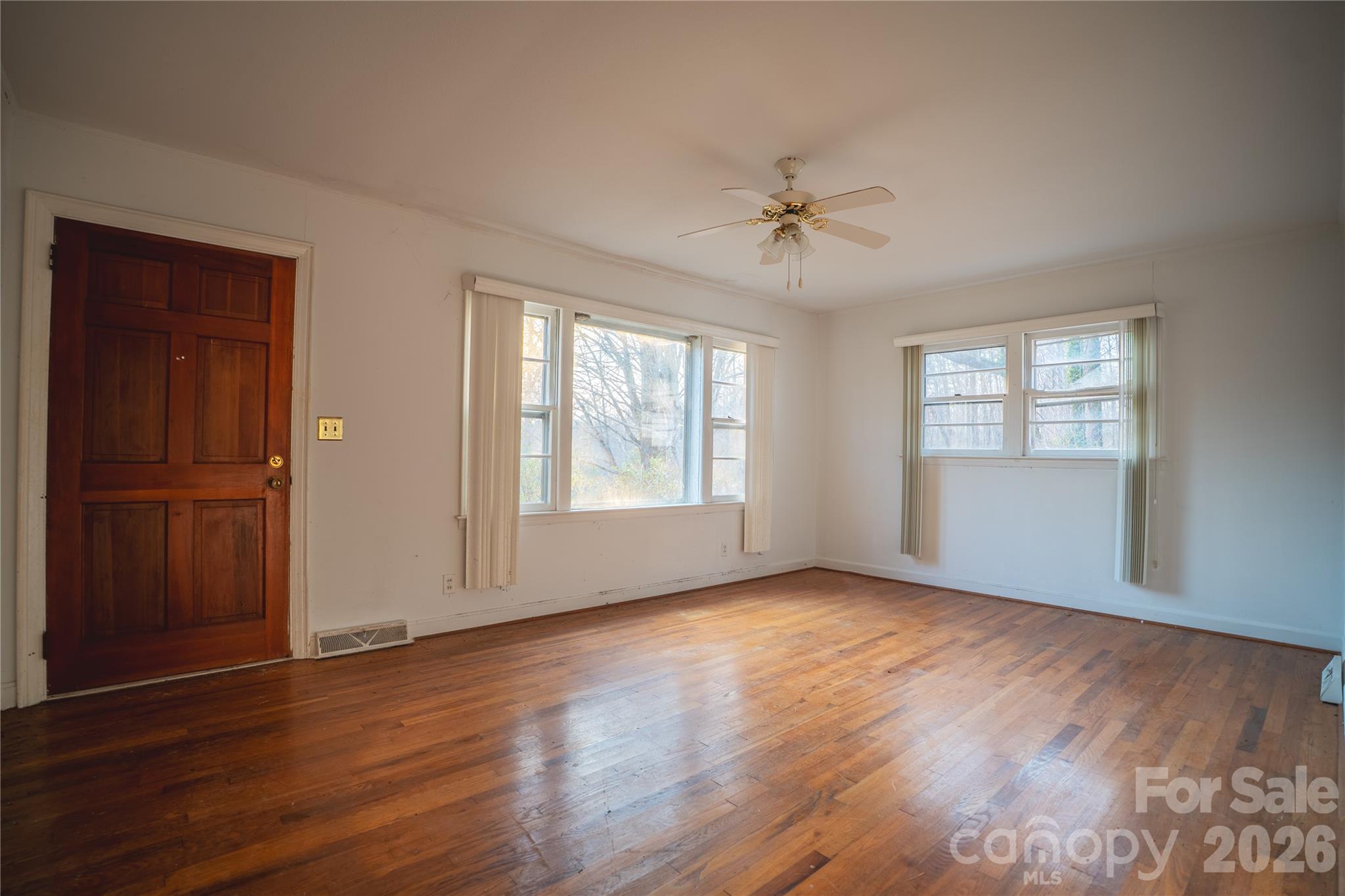 859 Stacy Hill Road Marion, NC 28752 - Photo 10 of 23 an empty room with wooden floor chandelier fan and windows