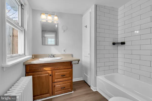 a bathroom with a tub sink and mirror