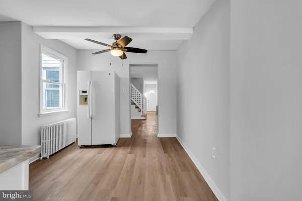 a view of a hallway with wooden floor and a chandelier fan