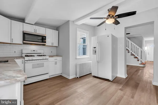 a kitchen with granite countertop a refrigerator and a stove top oven