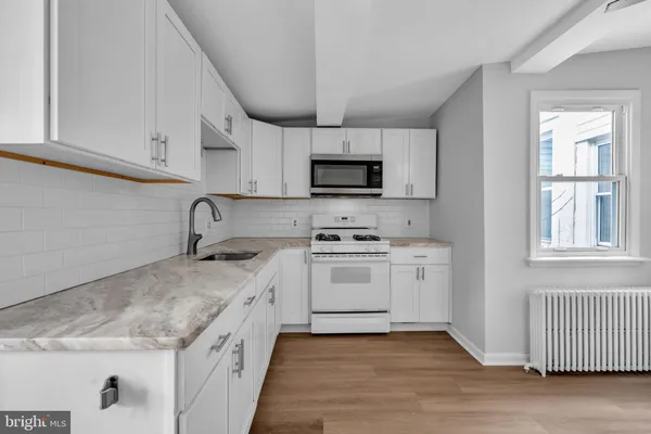 a kitchen with granite countertop a sink stainless steel appliances and cabinets