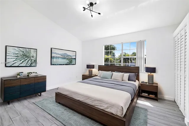 a spacious bedroom with a bed and a chandelier