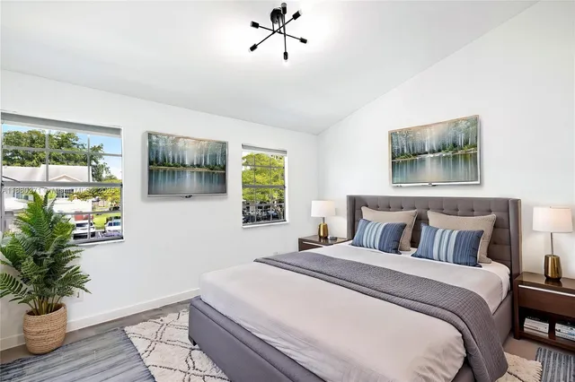 a bedroom with a large bed and a potted plant