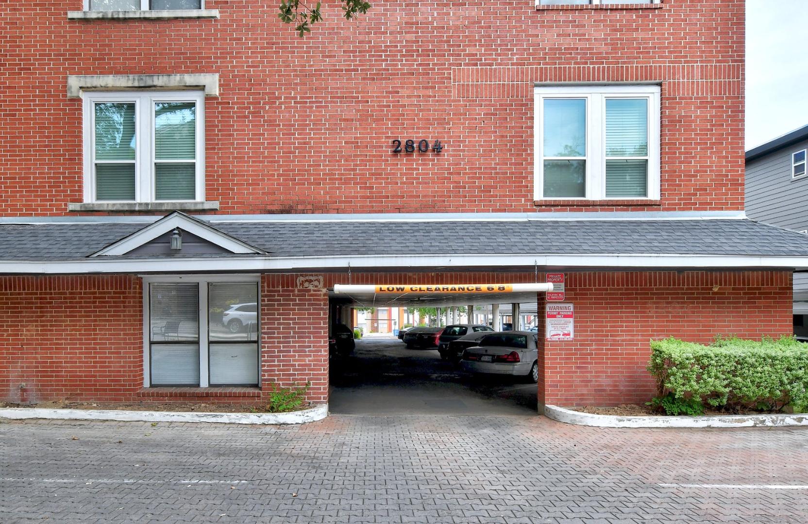 2804 Rio Grande Street, Unit 310 Austin, TX 78705 - Photo 21 of 22 A well-maintained brick building features convenient covered parking, ideal for urban living.