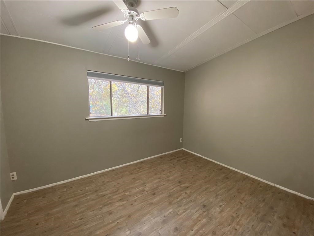 2413 Leon Street, Unit 101 Austin, TX 78705 - Photo 12 of 22 an empty room with a chandelier fan and windows
