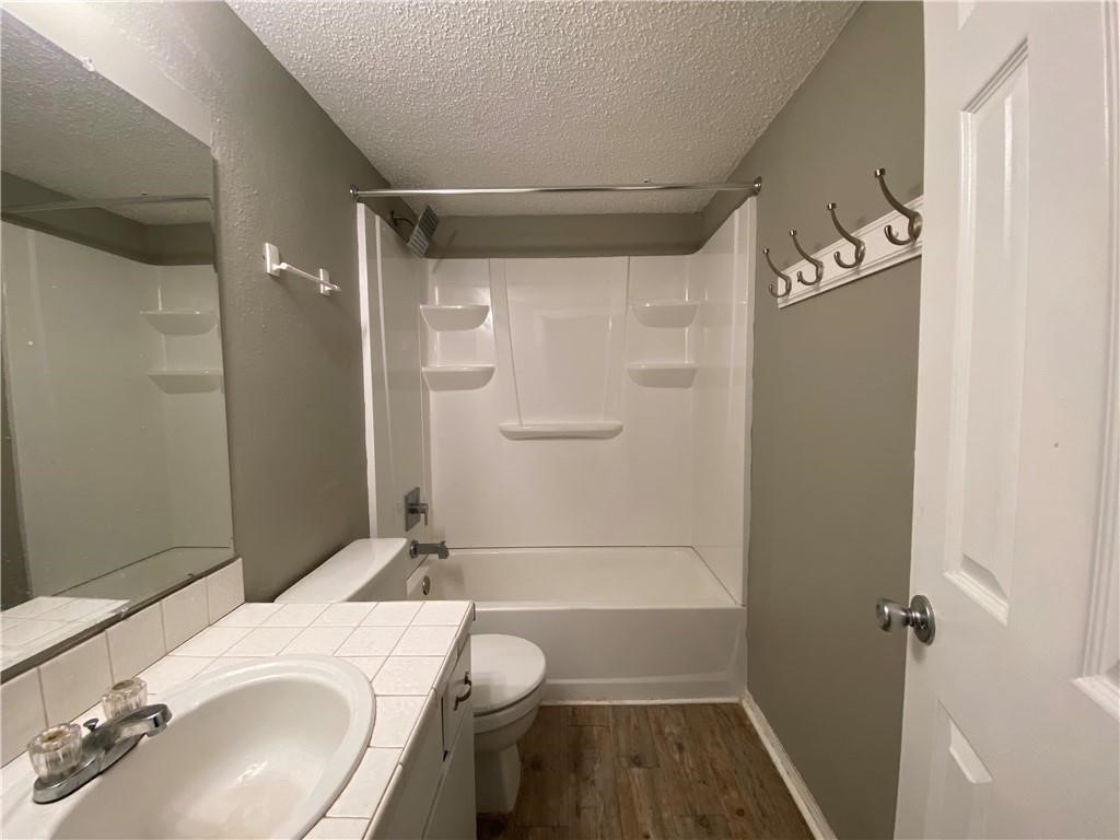 2413 Leon Street, Unit 101 Austin, TX 78705 - Photo 16 of 22 a bathroom with a granite countertop sink toilet and shower