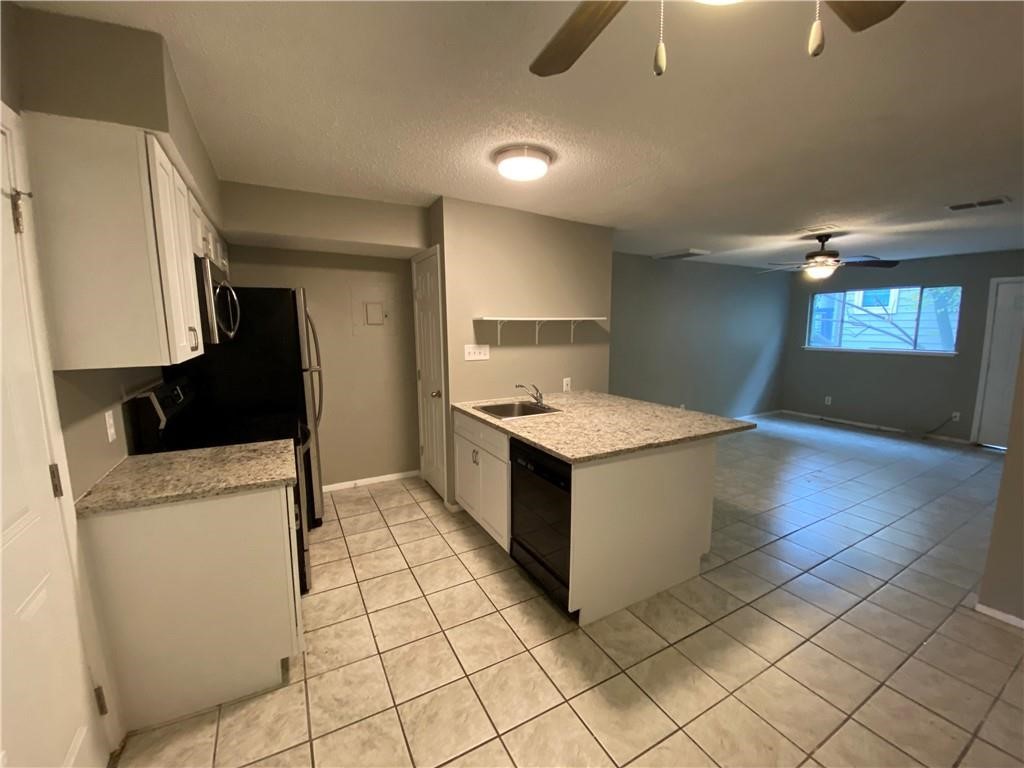2413 Leon Street, Unit 101 Austin, TX 78705 - Photo 6 of 22 a kitchen with a sink a stove and cabinets