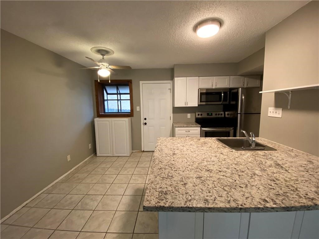 2413 Leon Street, Unit 101 Austin, TX 78705 - Photo 7 of 22 a kitchen with a stove a sink and a refrigerator