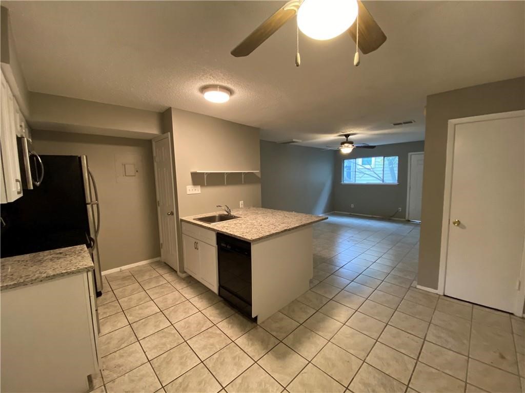 2413 Leon Street, Unit 101 Austin, TX 78705 - Photo 8 of 22 a kitchen with a sink and a refrigerator