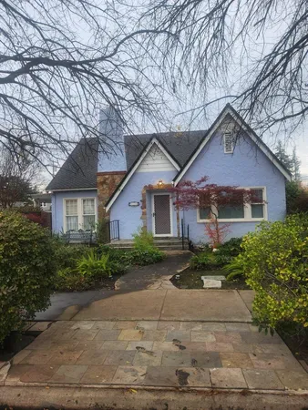 a front view of a house with a yard and trees