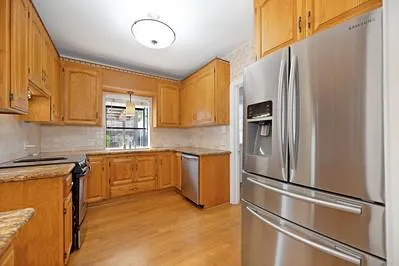 a kitchen with stainless steel appliances granite countertop a refrigerator a stove and a sink