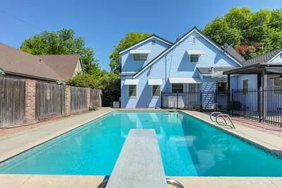 a view of a house with pool and chairs