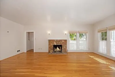 a view of an empty room with window and fire place
