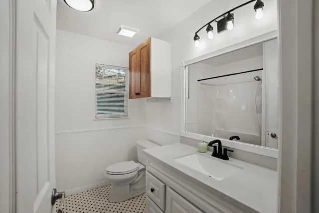 a bathroom with a sink toilet and mirror