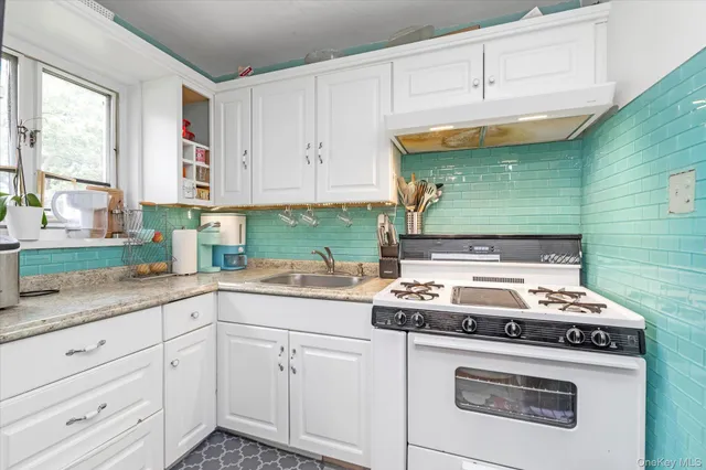 a kitchen with granite countertop cabinets stove top oven and sink