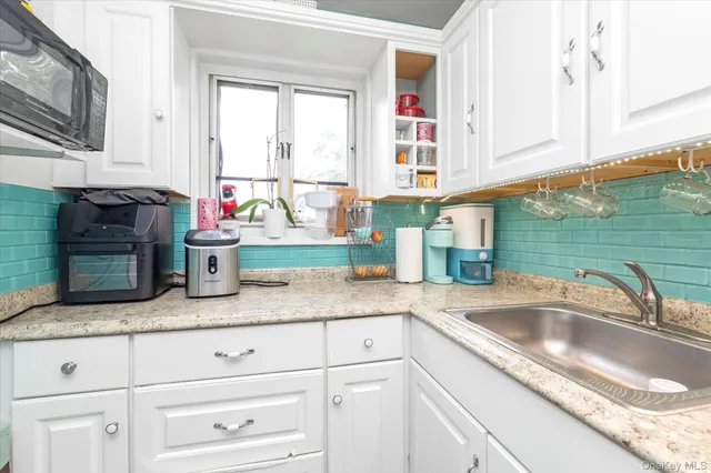 a kitchen with granite countertop stainless steel appliances sink and cabinets