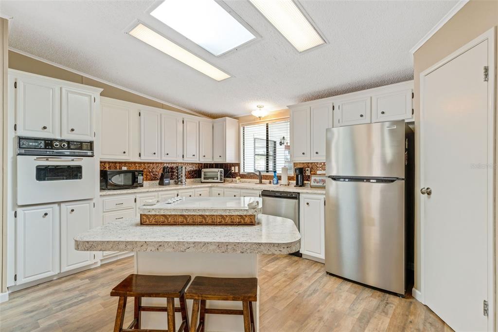 70 Mockingbird Lane Ellenton, FL 34222 - Photo 14 of 67 a kitchen with white cabinets and white stainless steel appliances