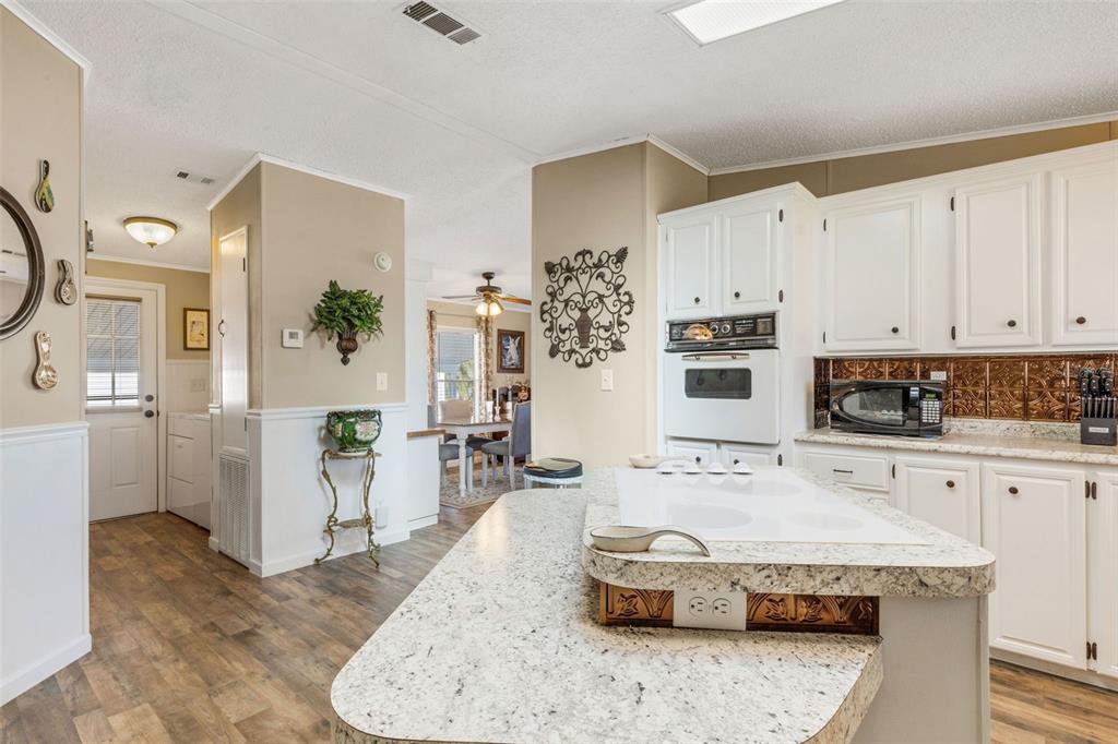 70 Mockingbird Lane Ellenton, FL 34222 - Photo 19 of 67 a kitchen with stainless steel appliances granite countertop a stove a sink and white cabinets