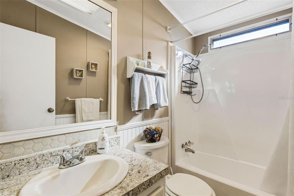 70 Mockingbird Lane Ellenton, FL 34222 - Photo 7 of 67 a bathroom with a granite countertop sink toilet a shower and a mirror