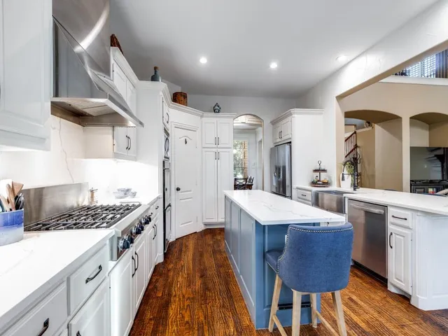 a kitchen with stainless steel appliances granite countertop a sink stove and refrigerator