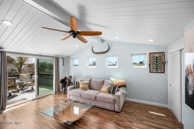 a living room with furniture and a ceiling fan
