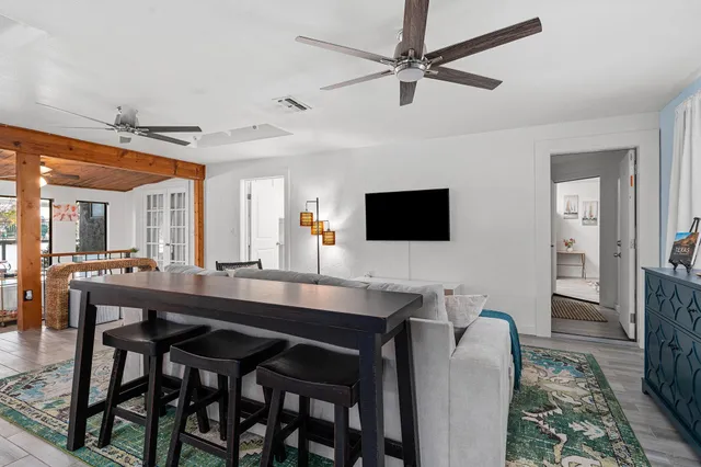 a living room with furniture a clock and a ceiling fan