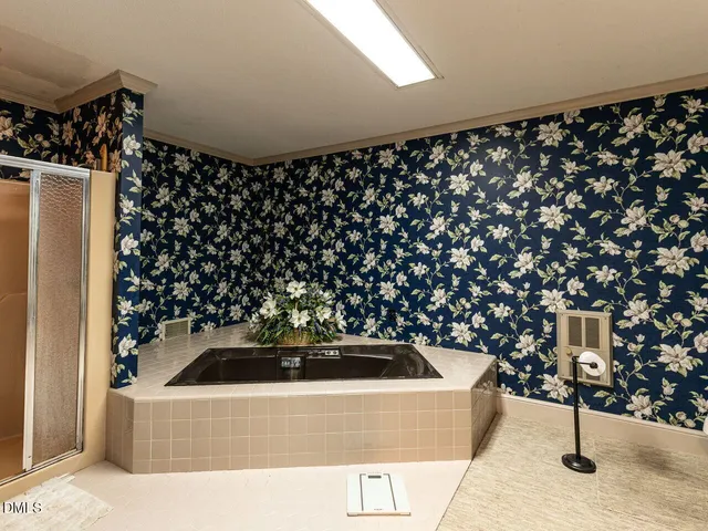 a view of a hallway with wooden floor and a bathroom