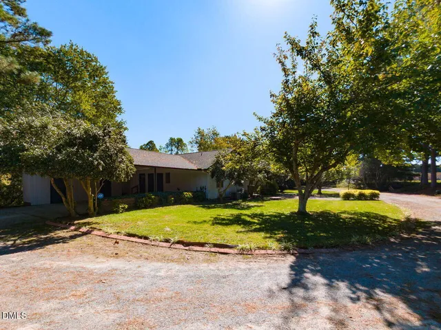 a dining room with wooden floor a chandelier a wooden table and chairs
