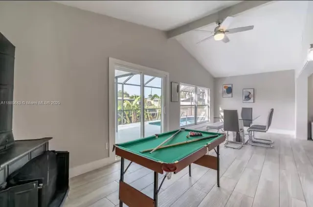 a room with pool table and windows