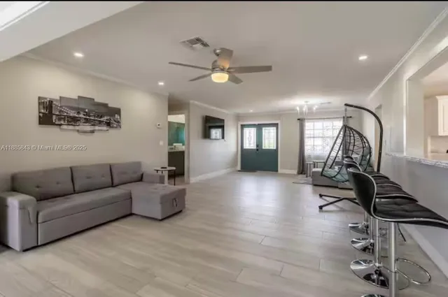 a living room with furniture and a wooden floor