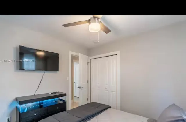 a living room with a flat screen tv and a lamp